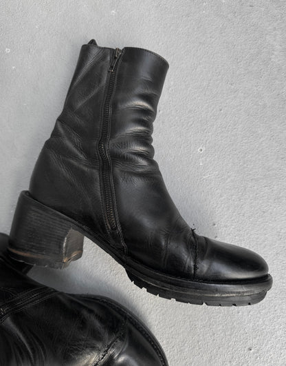 Black leather boots with a zipper on a gray background