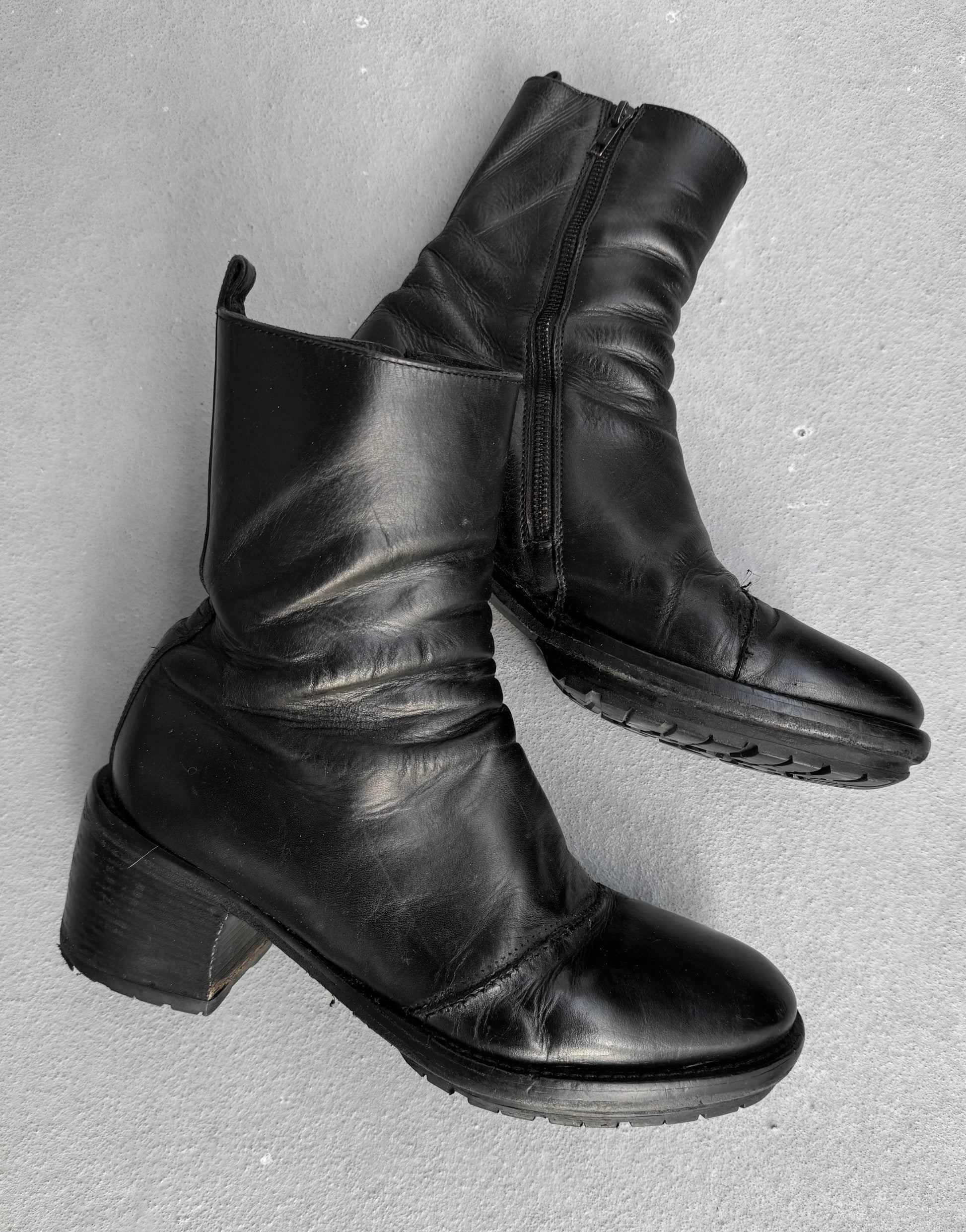 Pair of black leather ankle boots on a gray background