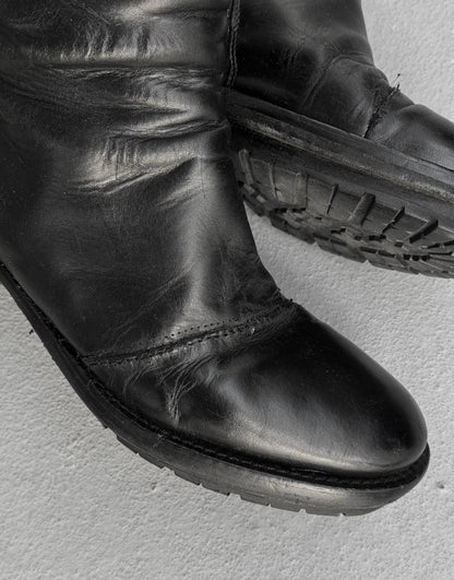 Black leather boot on a light gray background