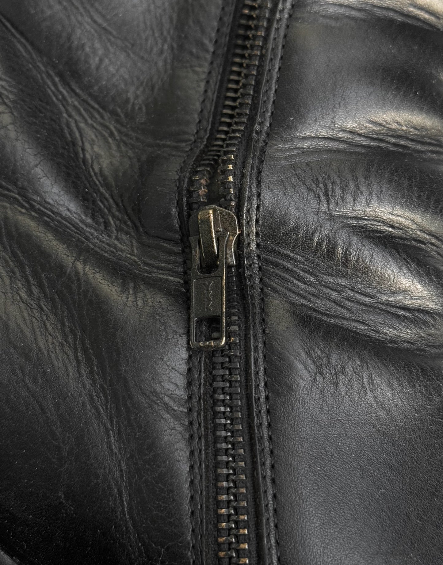 Close-up of a black leather jacket with a zipper