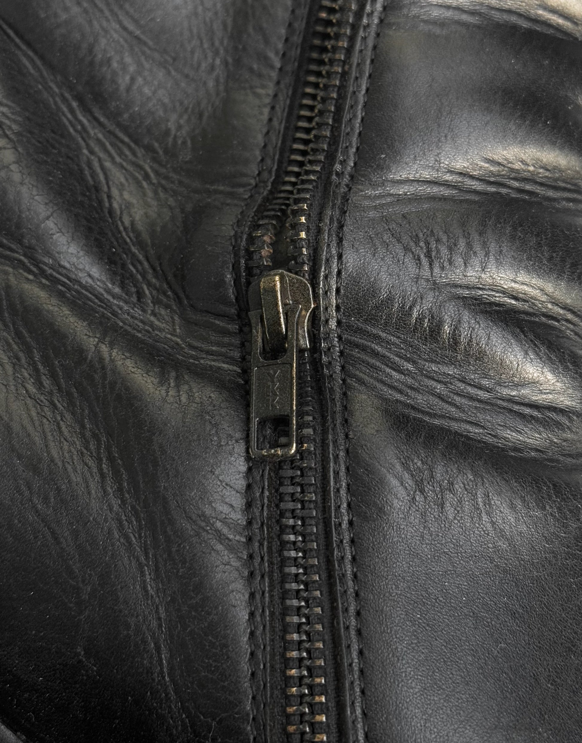 Close-up of a black leather jacket with a zipper