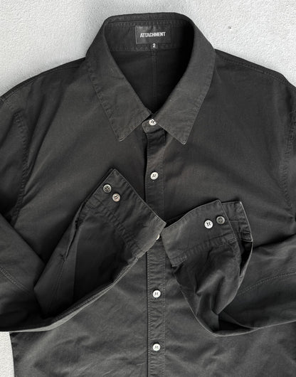 Black shirt with collar and button details on a gray background
