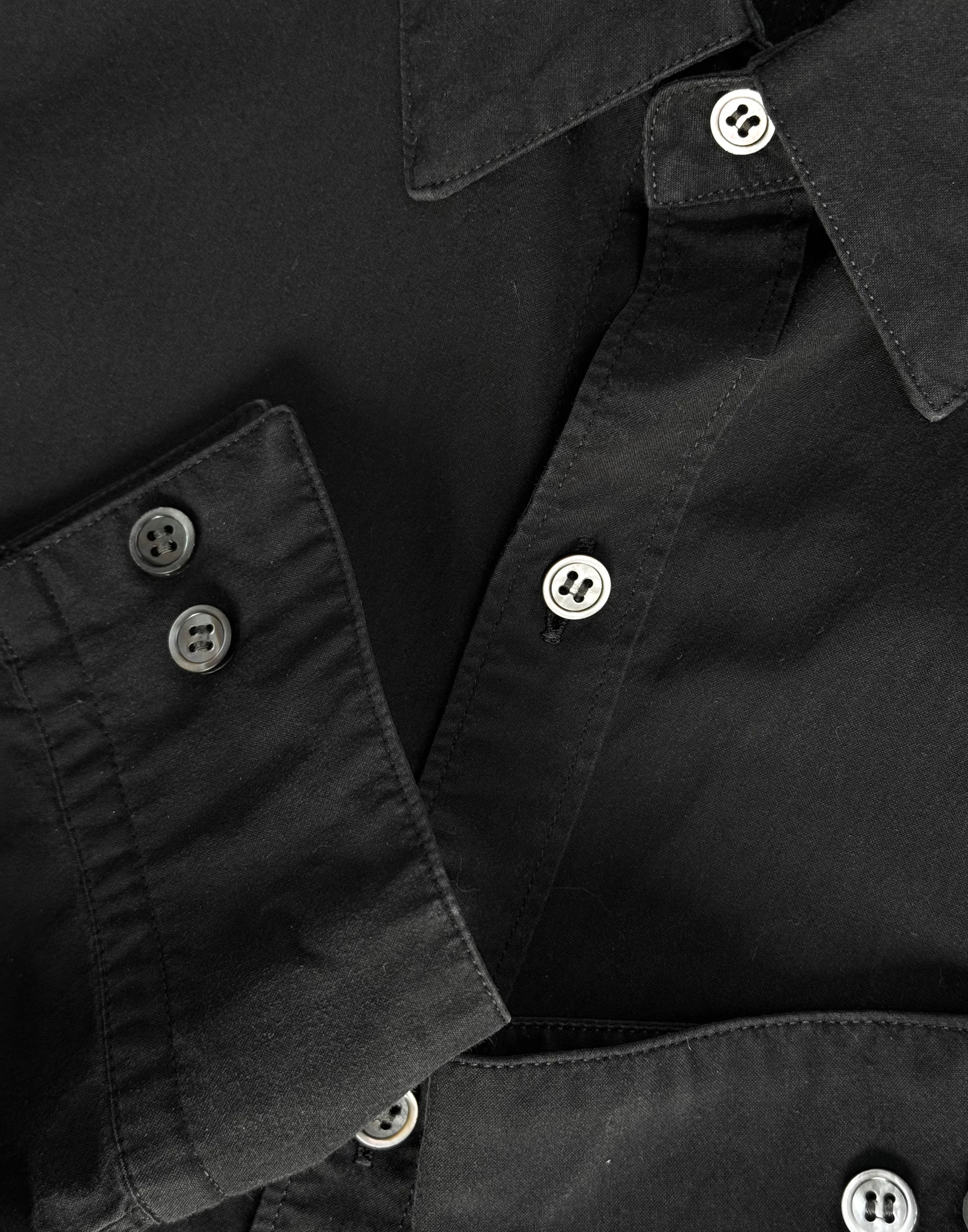 Close-up of a black shirt with buttons on a plain background