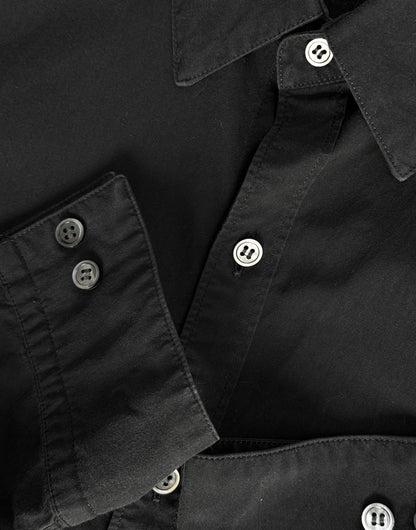 Close-up of a black shirt with buttons on a plain background