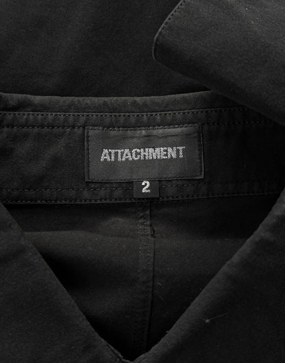 Close-up of a black jacket with 'Attachment' label and size tag.