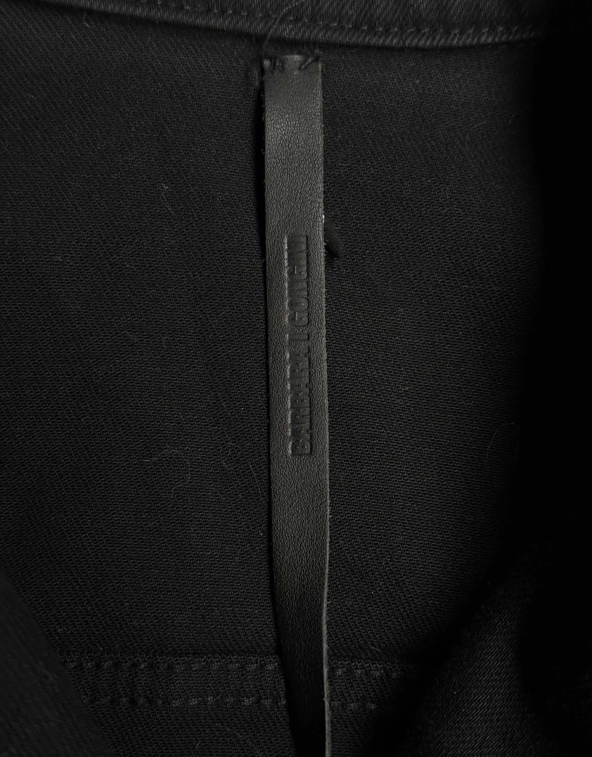 Close-up of a black fabric with a brand label on a black background