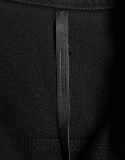 Close-up of a black fabric with a brand label on a black background