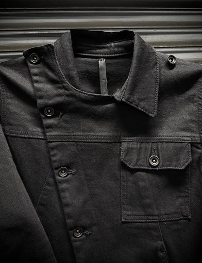 Close-up of a dark jacket with buttons and a zipper on a metallic surface