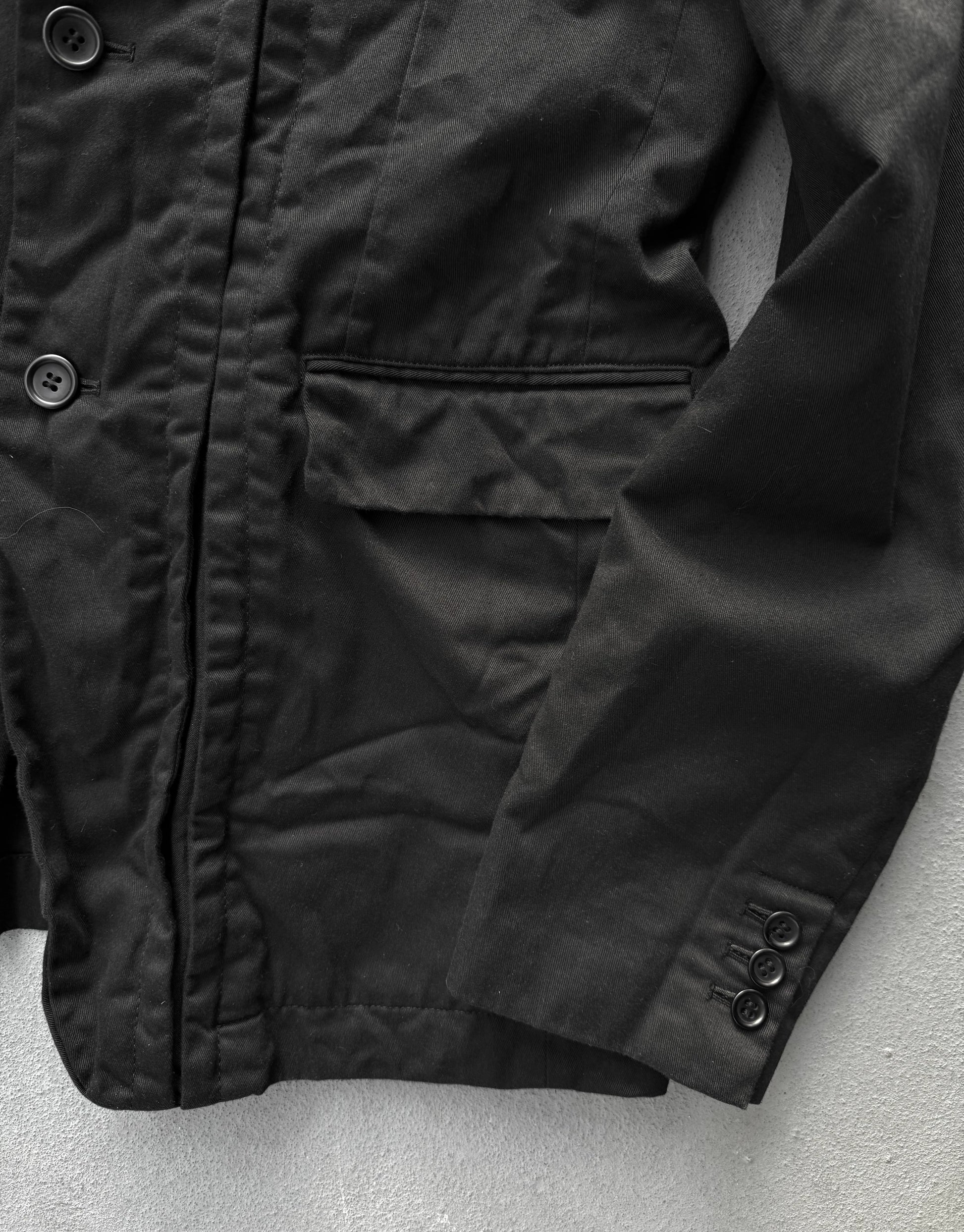 Close-up of a black jacket with buttons on a light gray background