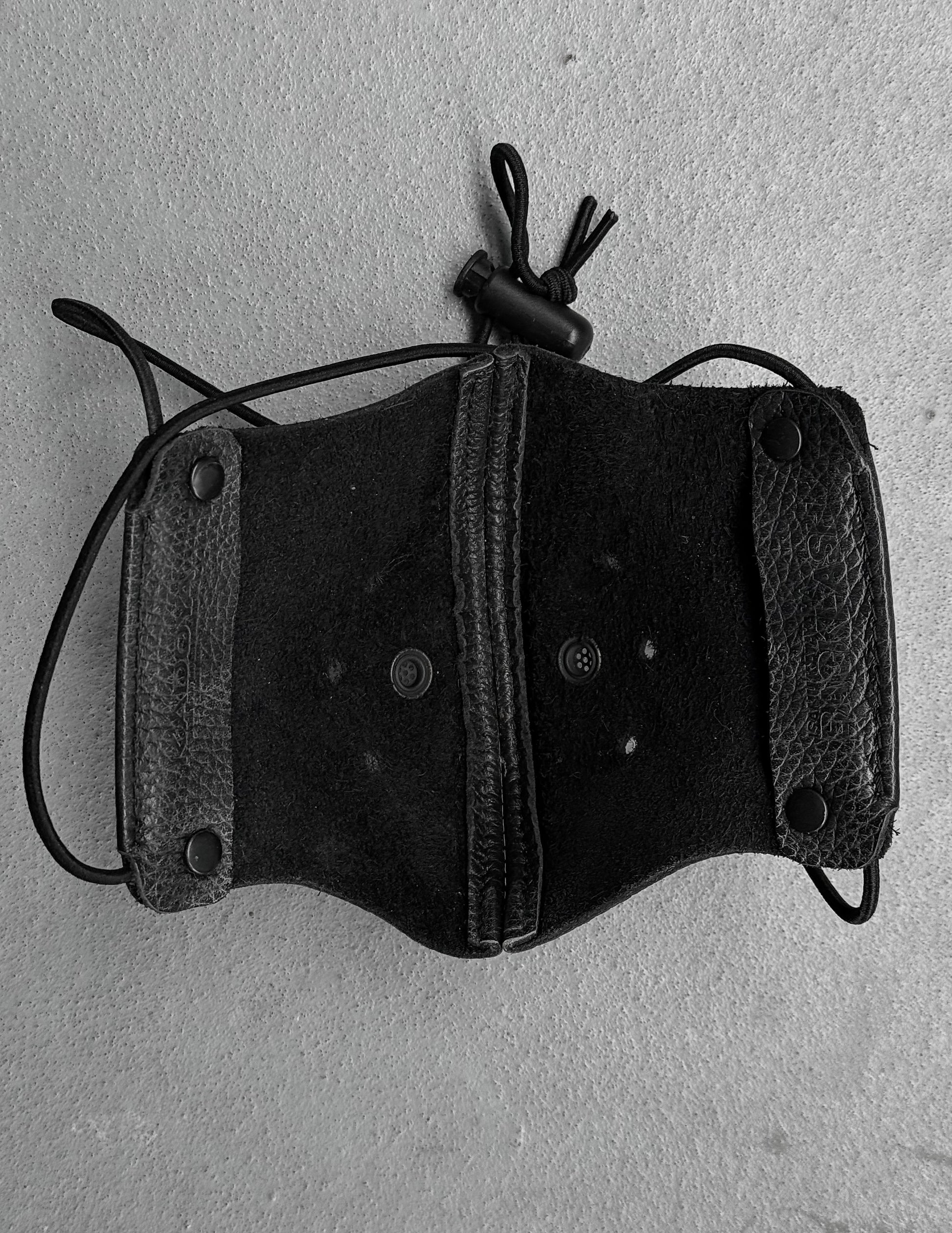Black leather holster with a rope on a gray background