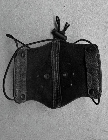 Black leather holster with a rope on a gray background