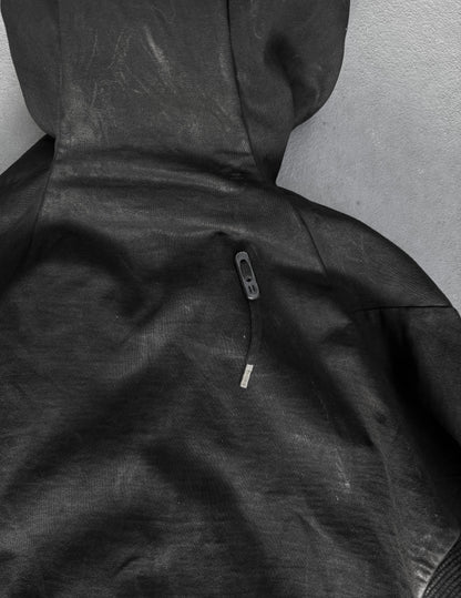 Close-up of a black hooded jacket with a zipper on a gray background