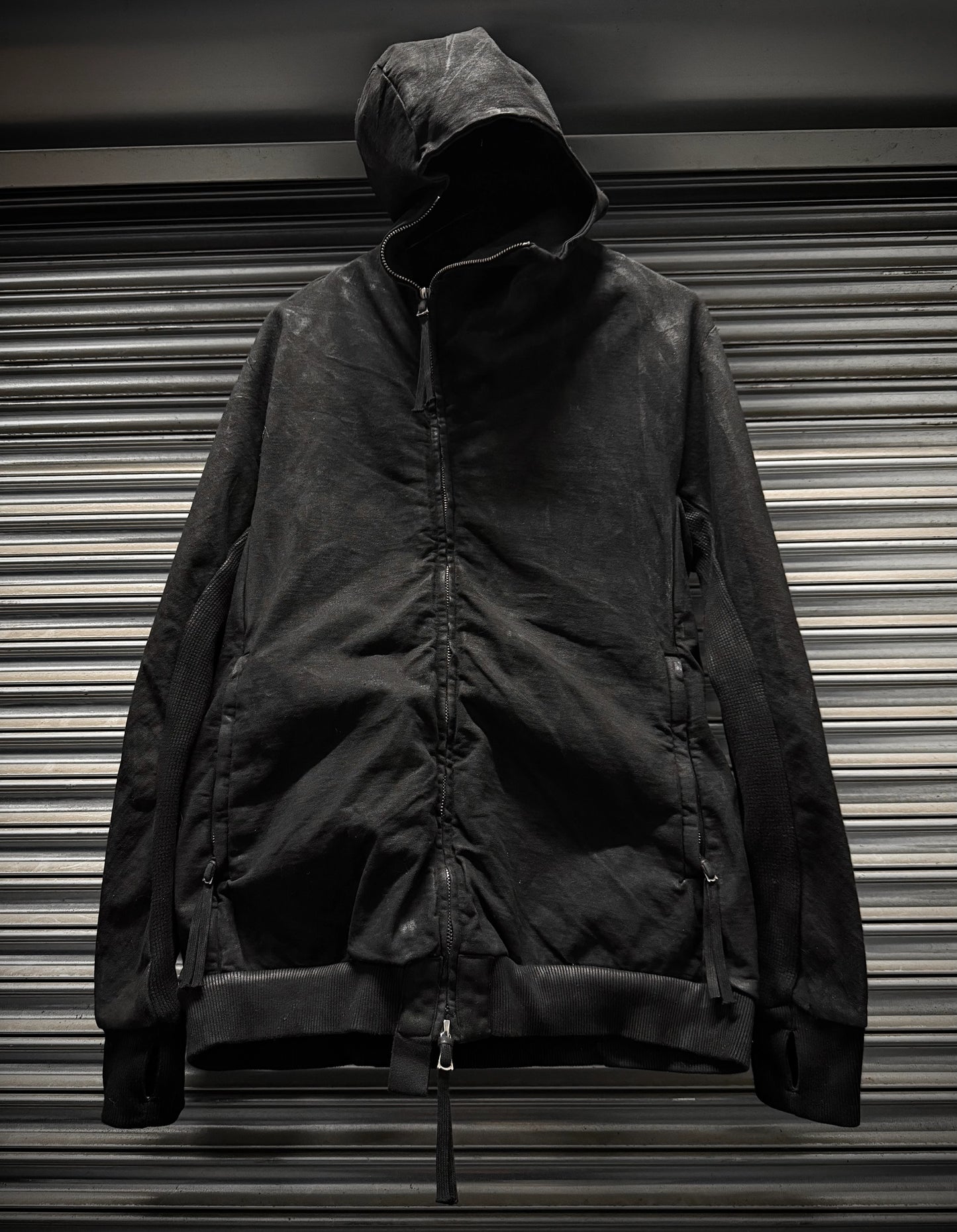 Black jacket with a hood on a metallic surface