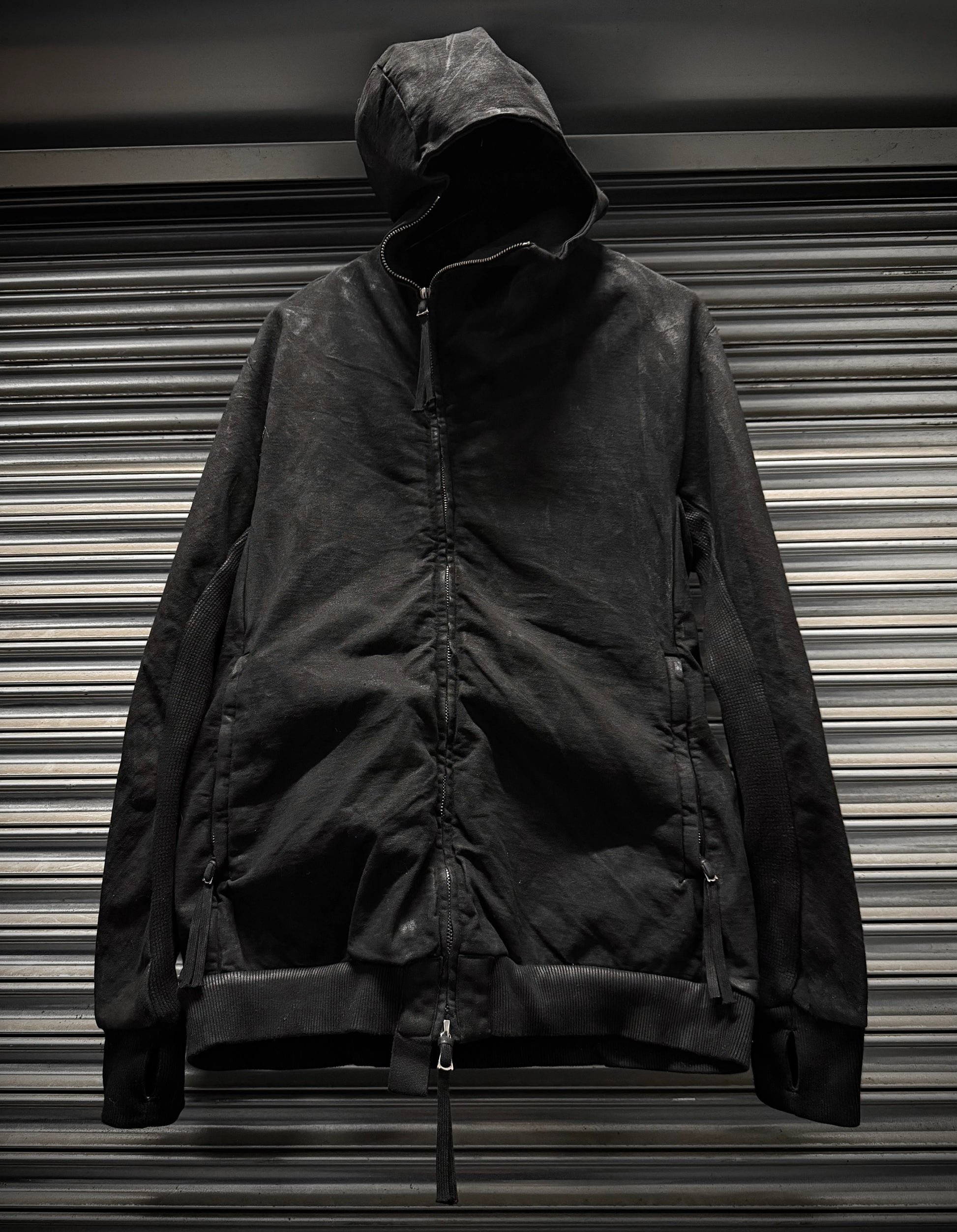 Black jacket with a hood on a metallic surface