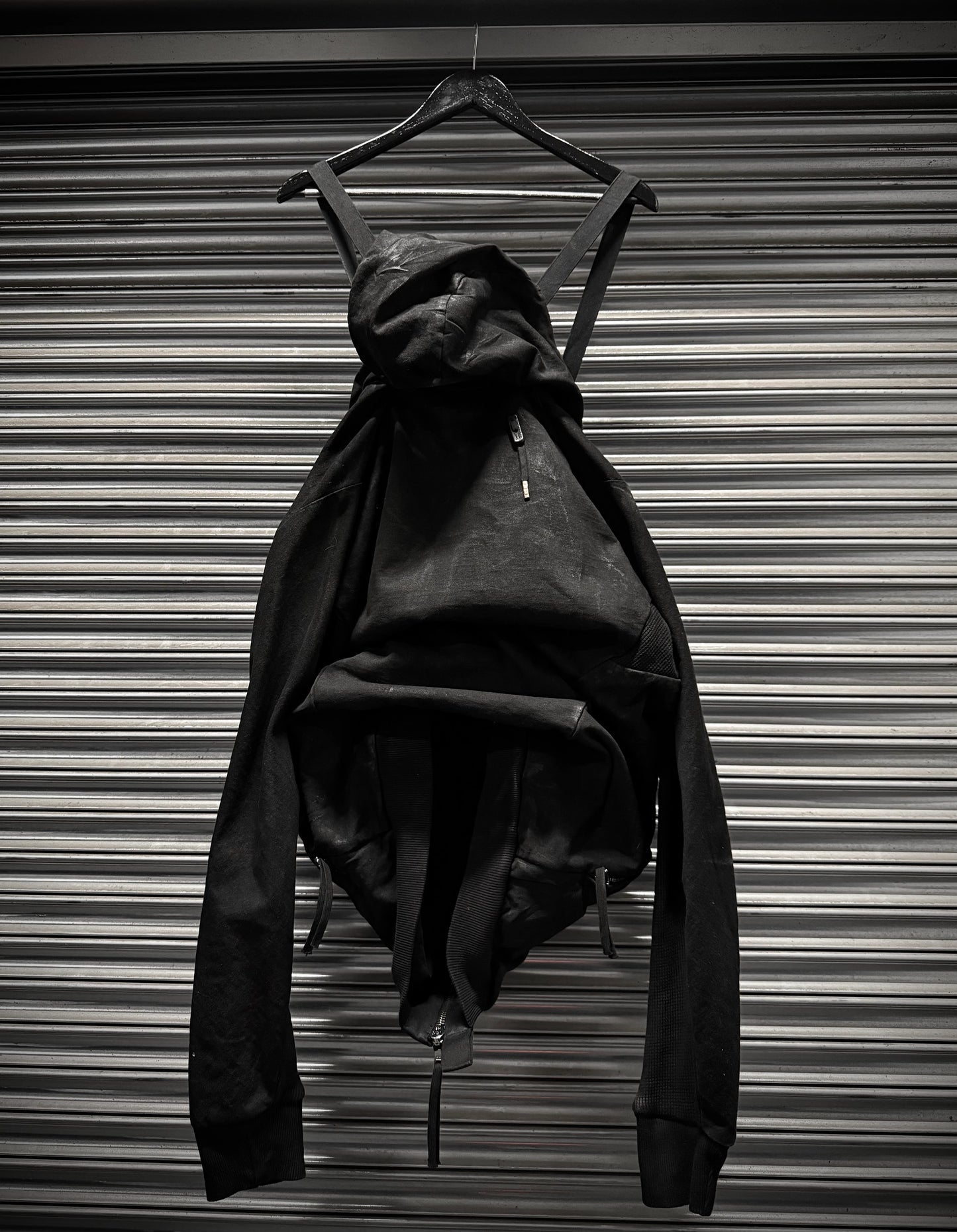 Black dress on a hanger against a metallic background