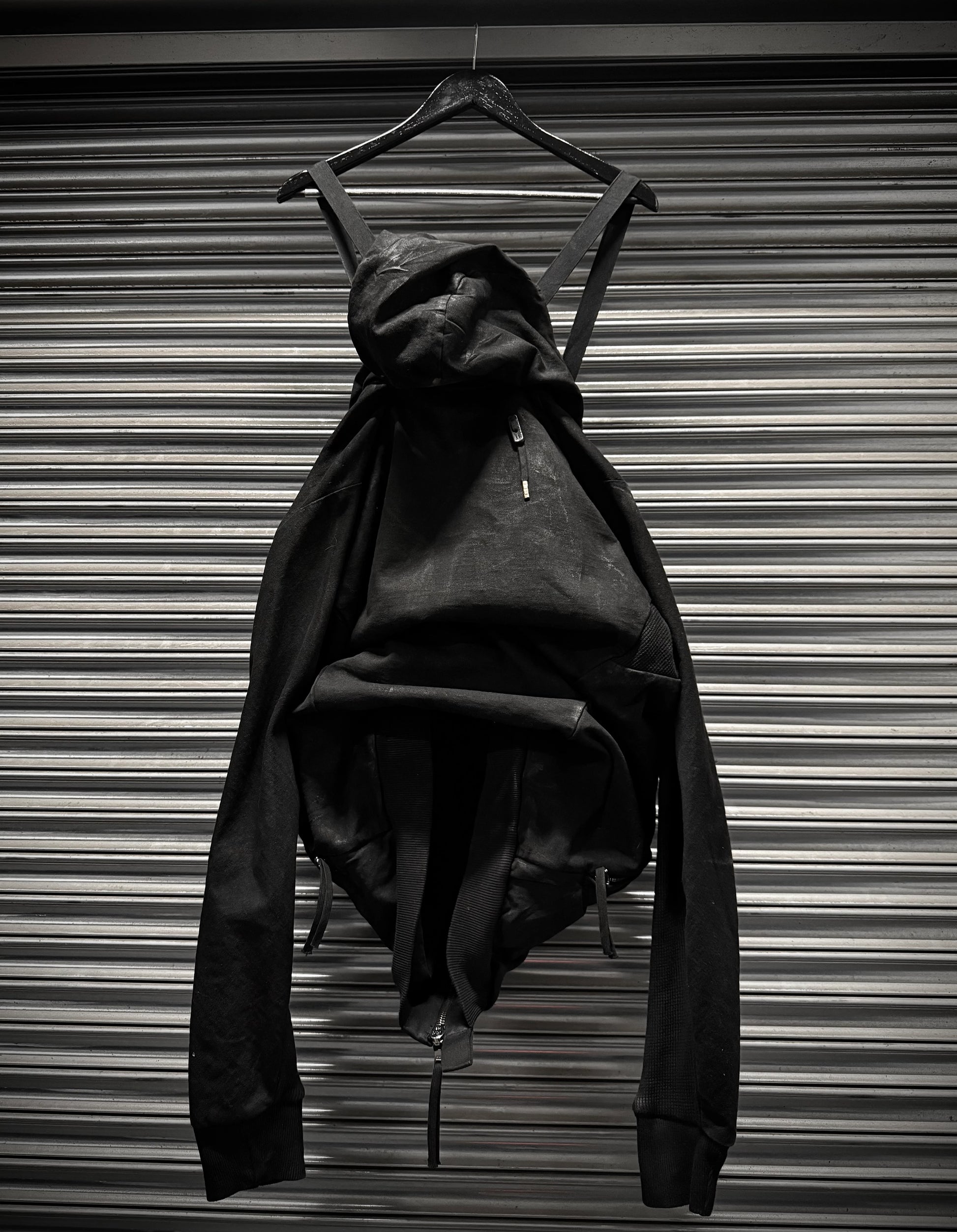 Black dress on a hanger against a metallic background