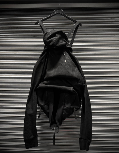 Black dress on a hanger against a metallic background
