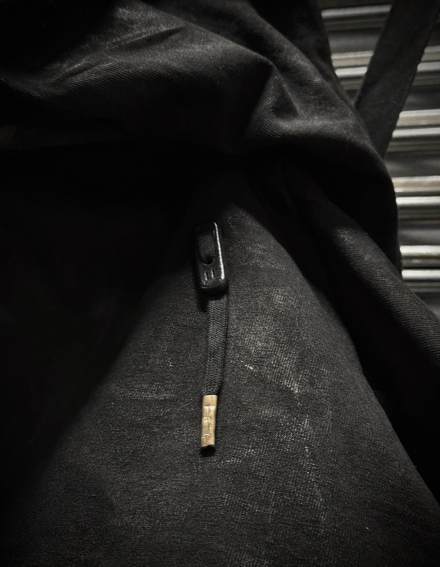 Close-up of a textured fabric with a button and label in black and white.