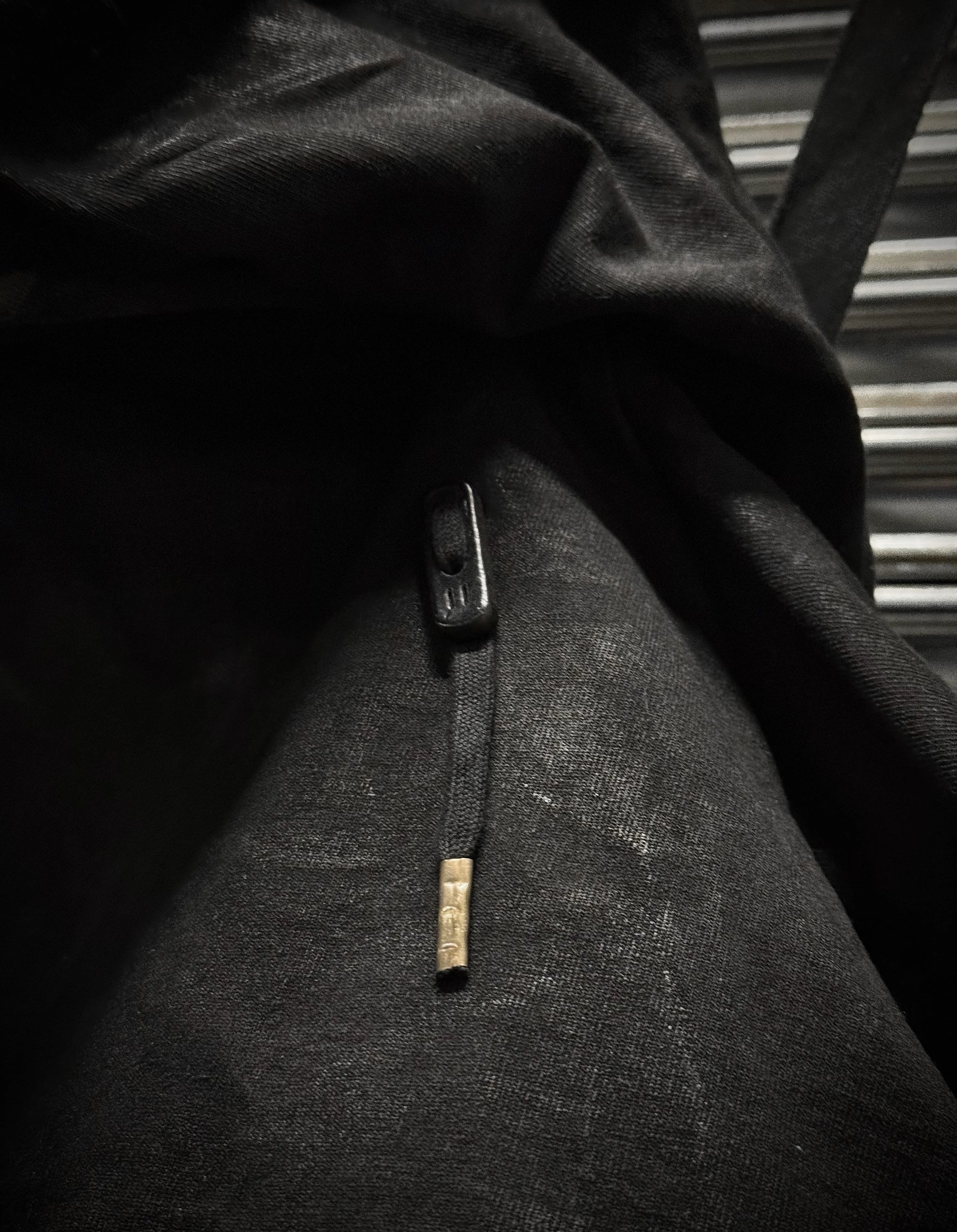 Close-up of a textured fabric with a button and label in black and white.