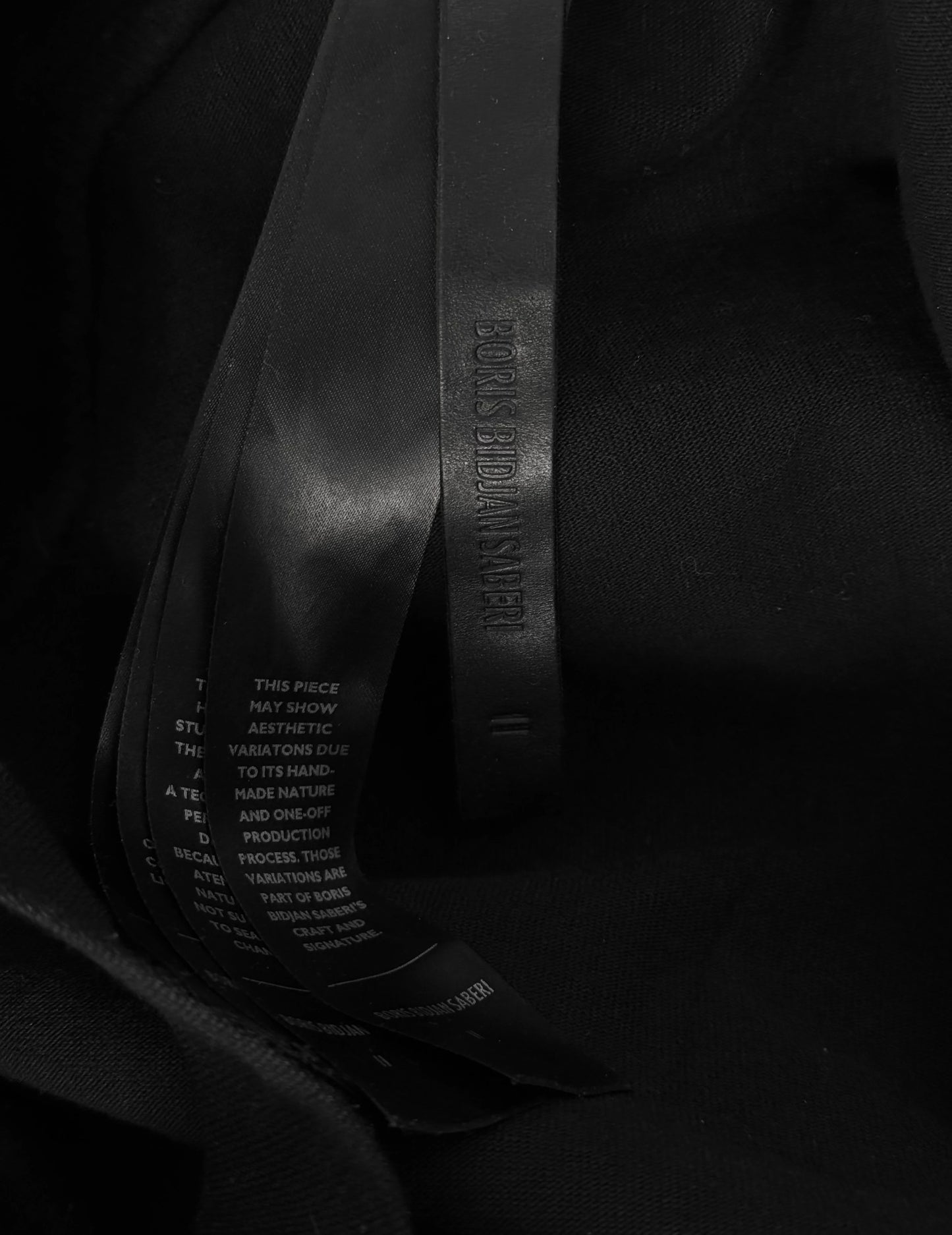 Black leather belt with brand name on a dark background