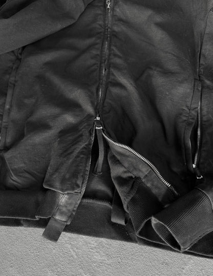 Close-up of a black jacket with zippers on a gray surface