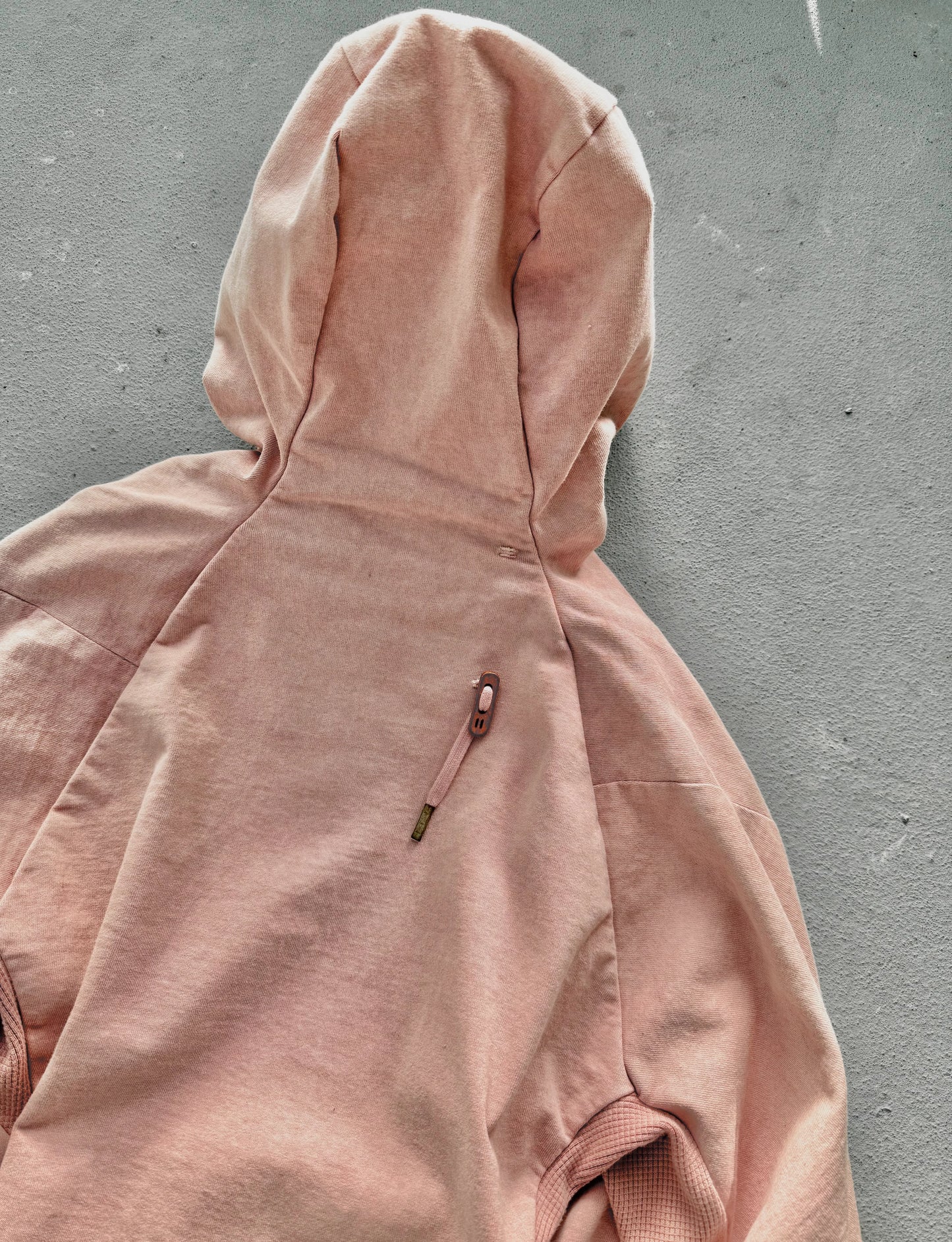 Pink hoodie on a gray surface