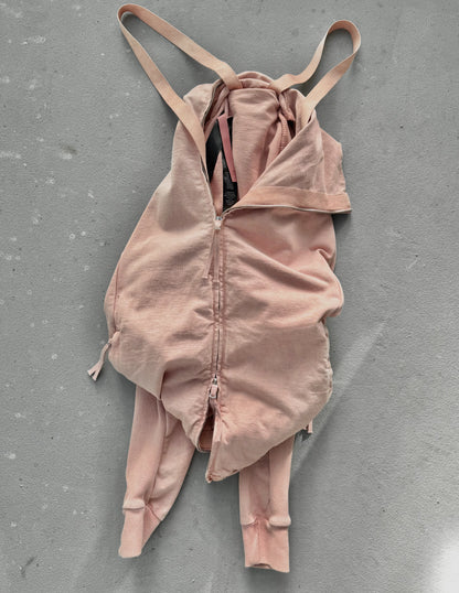 Pink bodysuit with thin straps on a gray surface