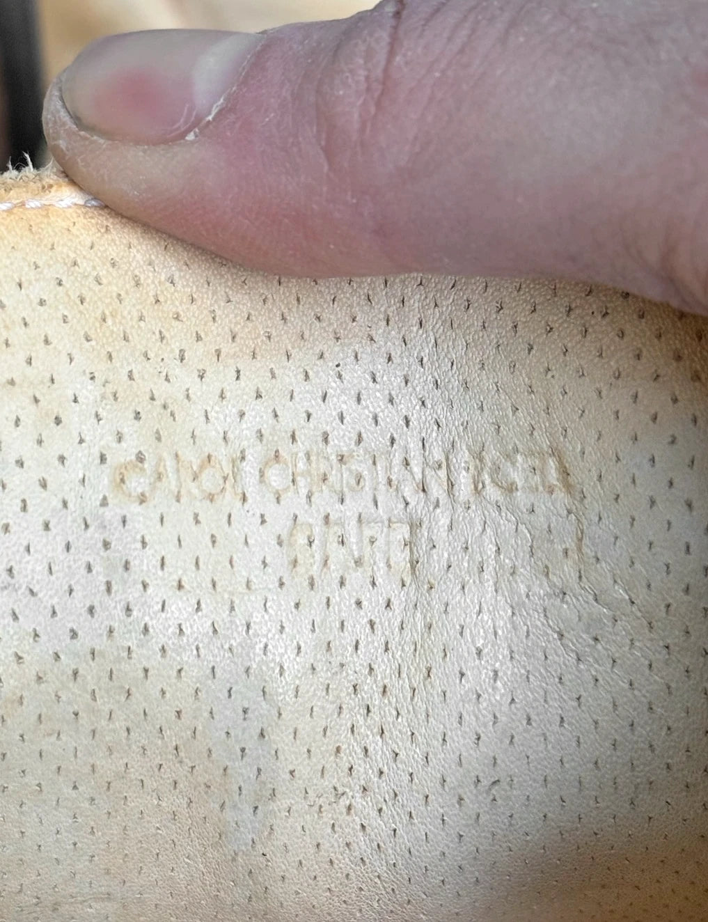 Close-up of a textured surface with a hand pressing down on it