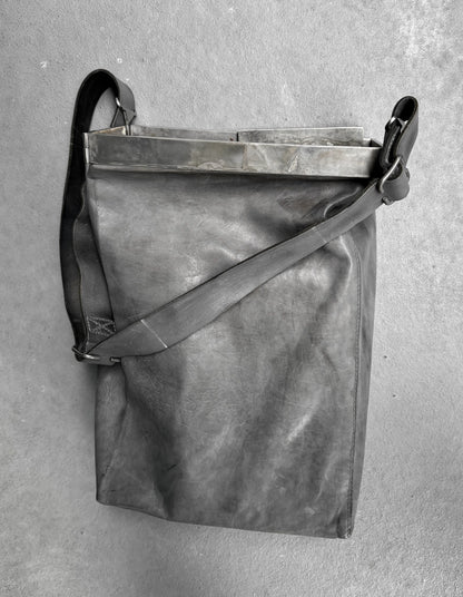 Gray leather bag with a strap on a gray background