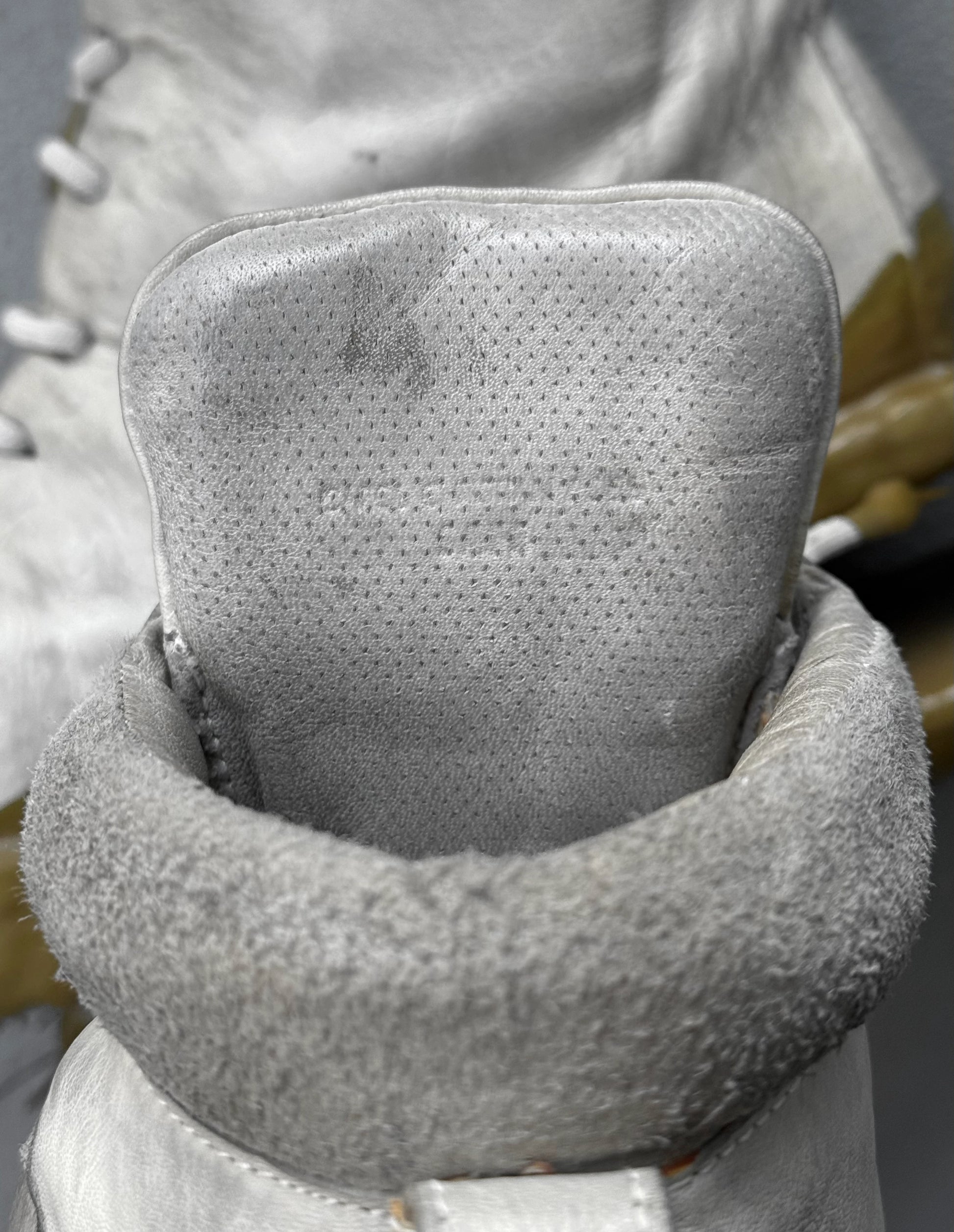 Close-up of a textured gray neck pillow with a blurred background