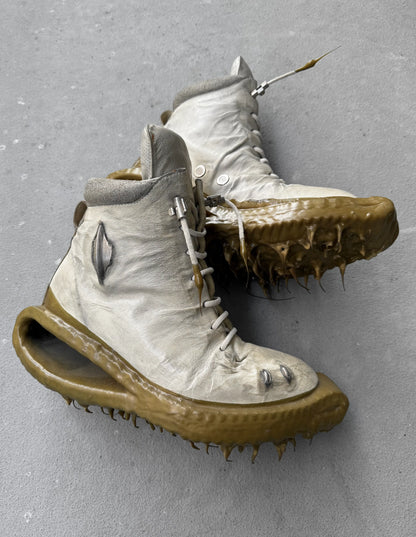 Pair of high-top shoes with unique sole design on a gray background