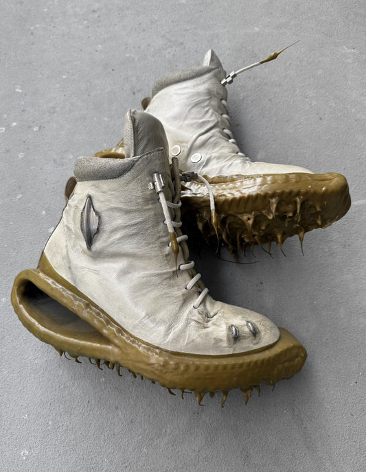 Pair of high-top shoes with unique sole design on a gray background