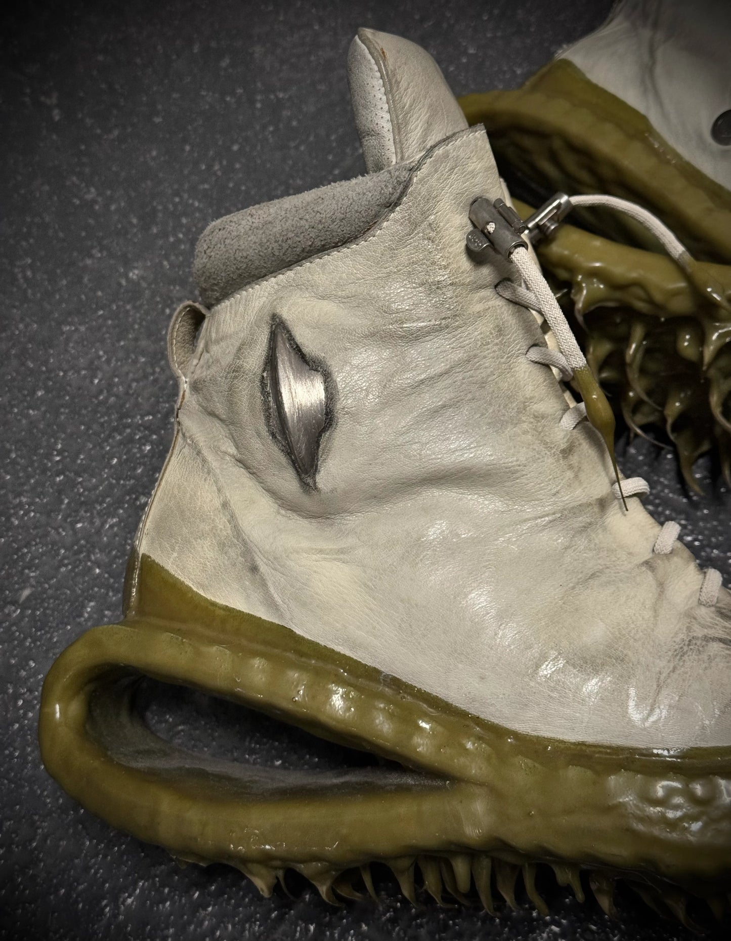 Close-up of a high-top sneaker with unique sole design on a dark surface