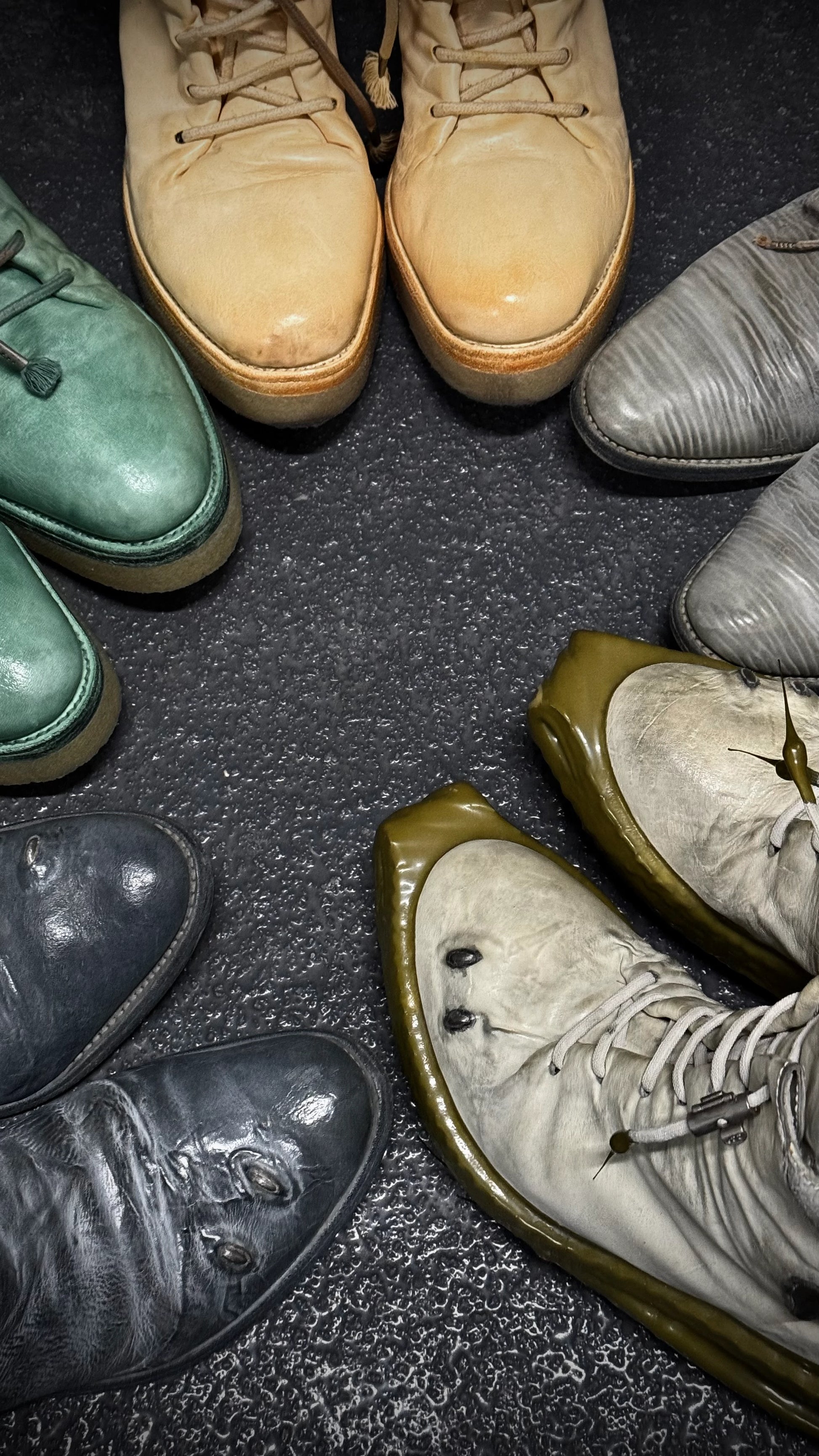 Collection of various shoes arranged in a circle on a textured surface.