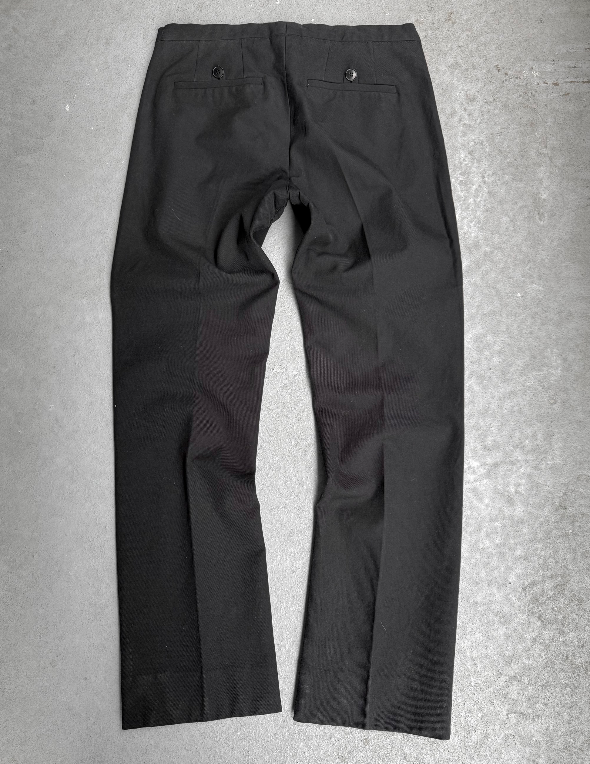 Black pants on a gray concrete surface