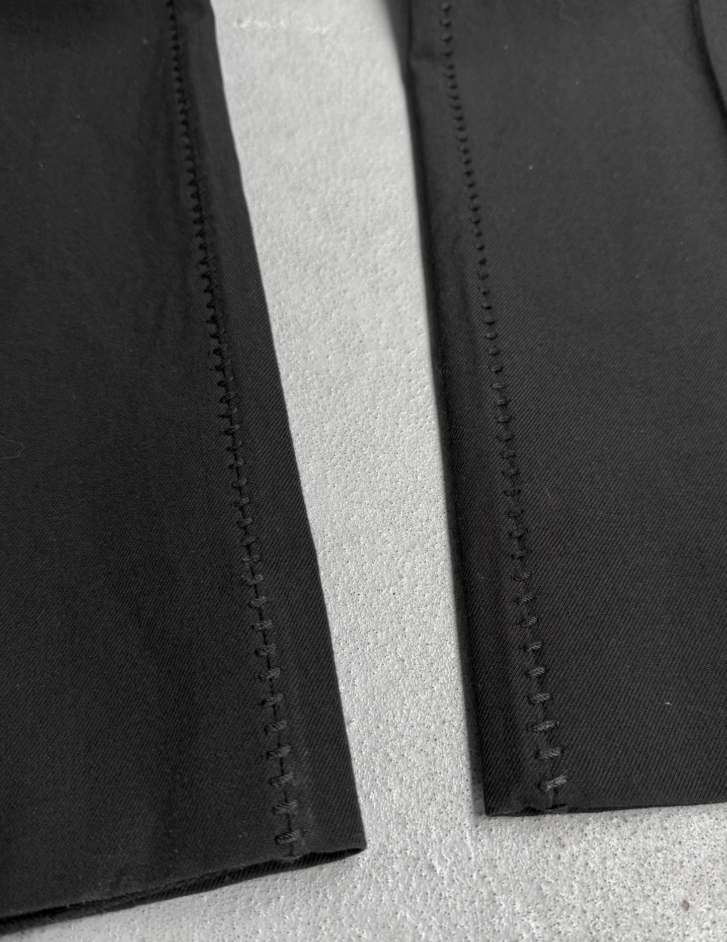 Close-up of black fabric with visible stitching on a gray background
