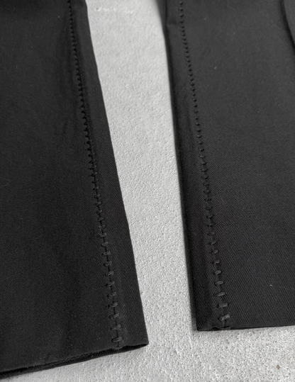 Close-up of black fabric with visible stitching on a gray background