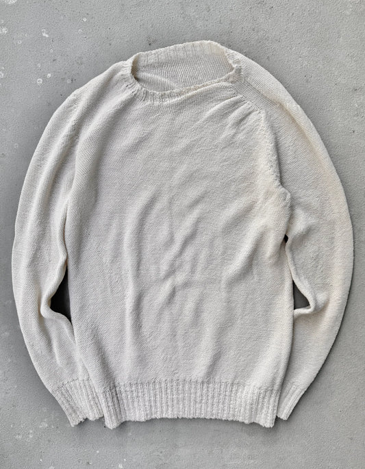 Light gray sweater on a gray concrete surface