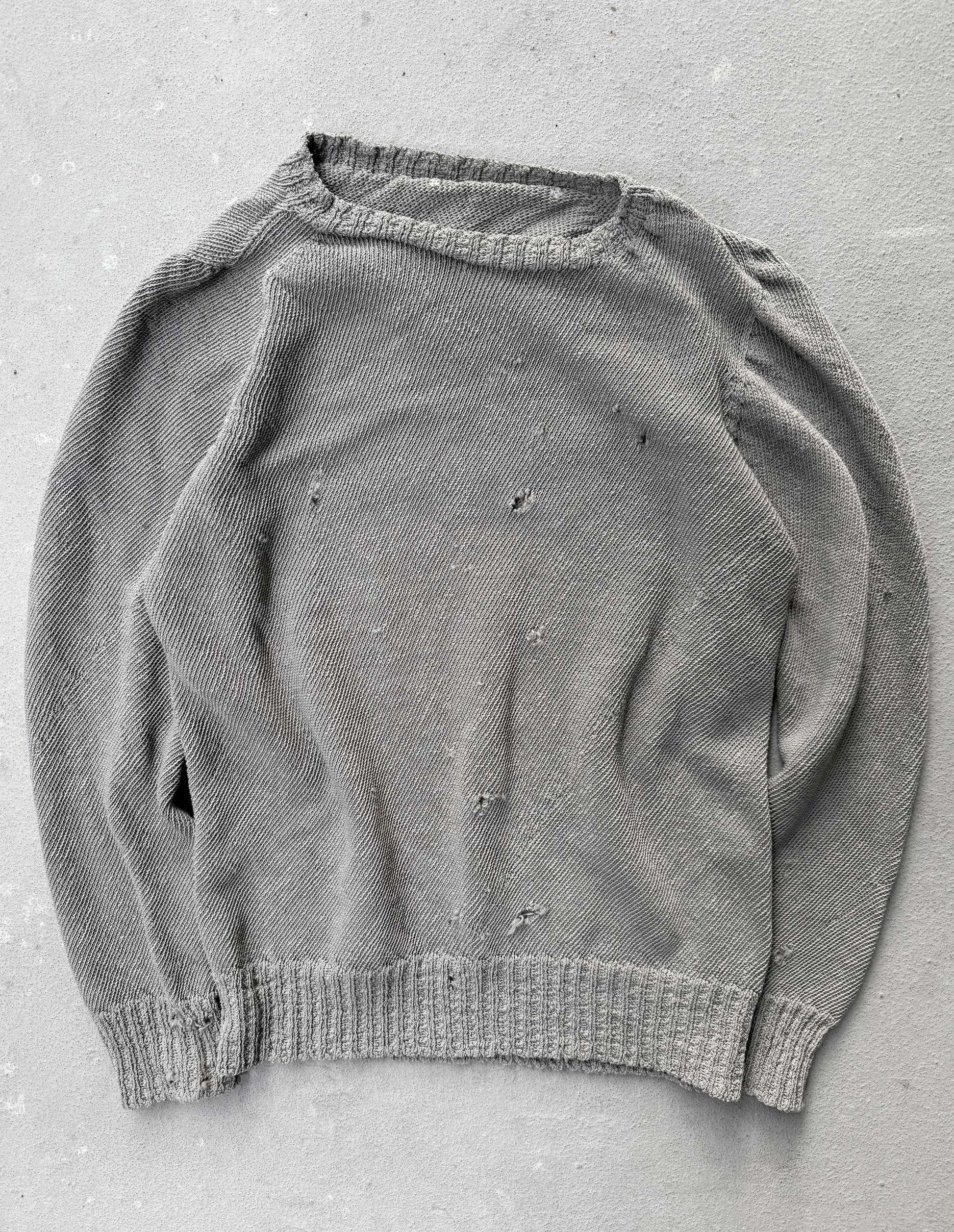 Gray sweater with visible wear on a gray background