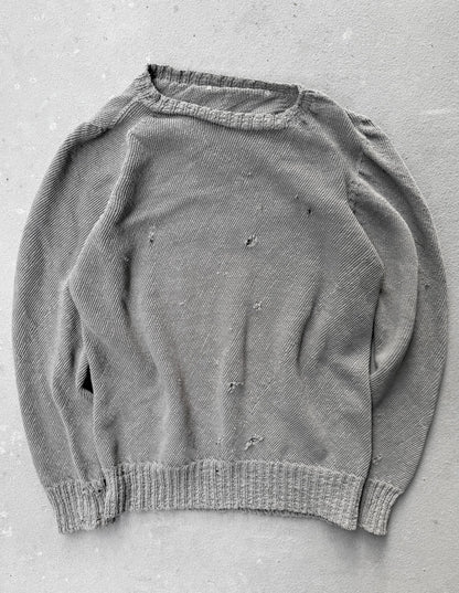 Gray sweater with visible wear on a gray background