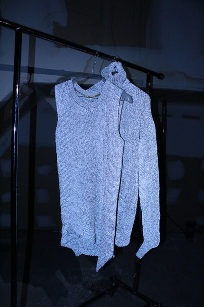 Light blue sweater on a hanger against a dark background