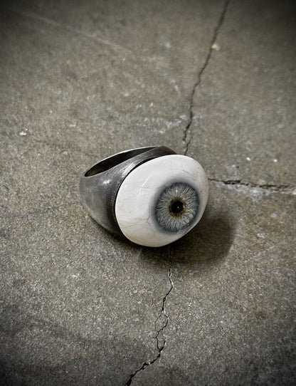 Ring with eye design on a concrete surface