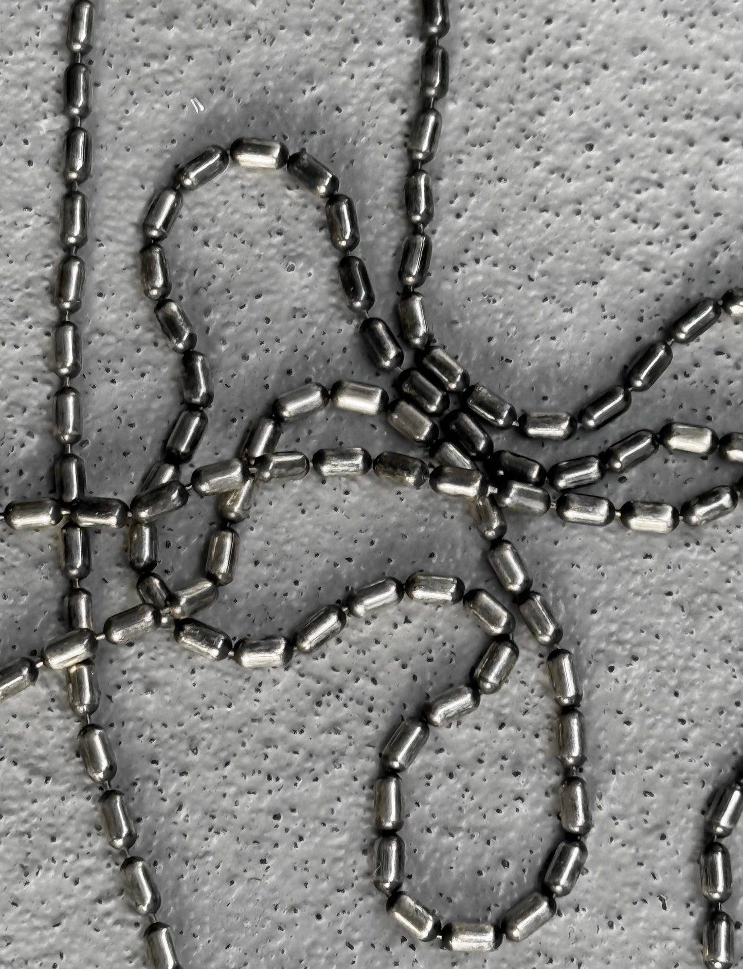 Close-up of metallic chainmail on a textured gray background