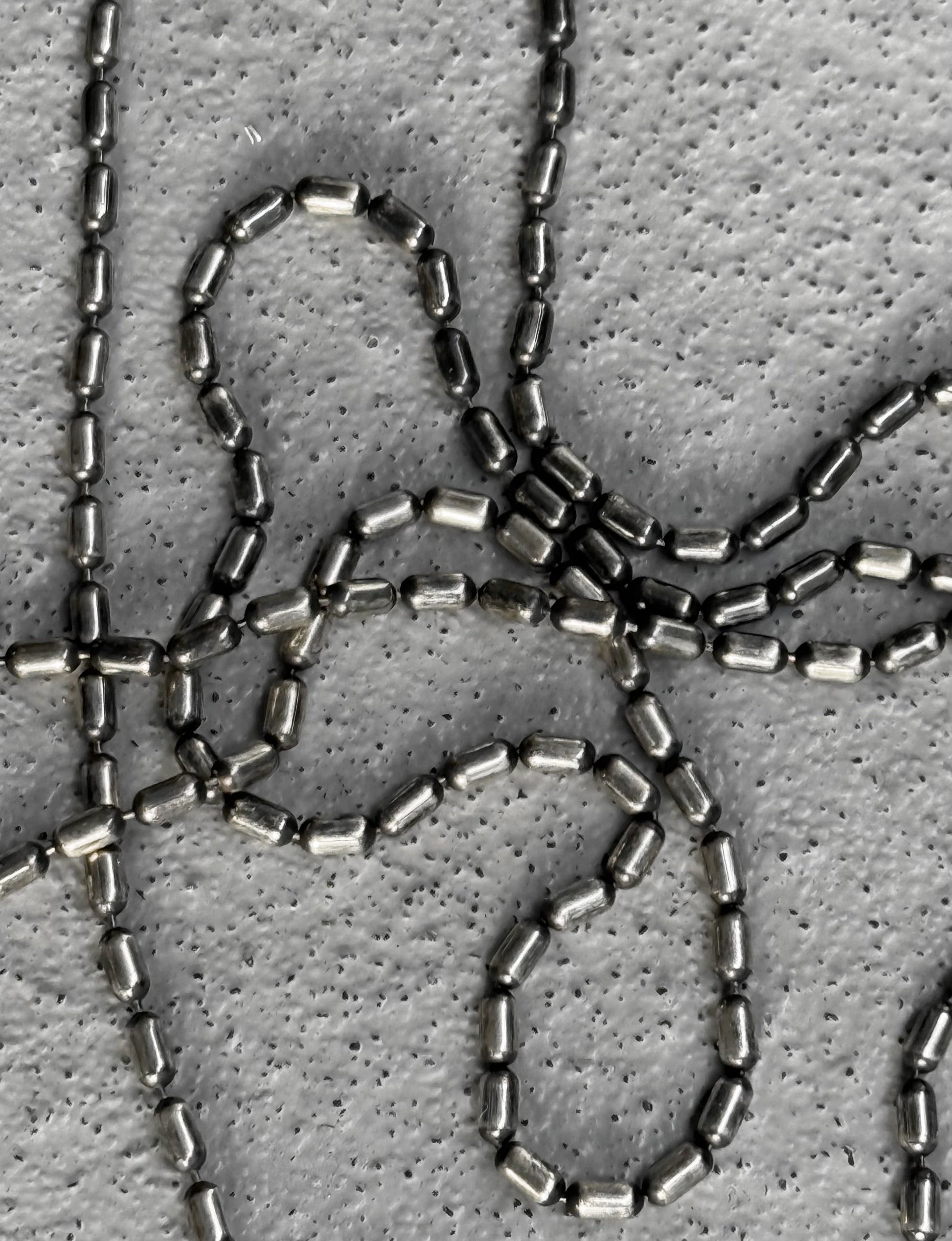 Close-up of metallic chainmail on a textured gray background