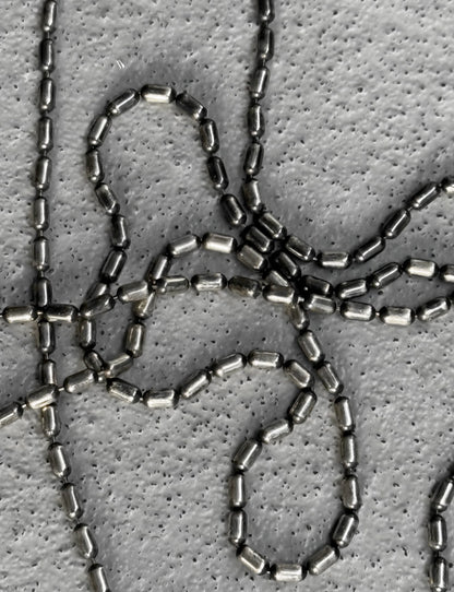 Close-up of metallic chainmail on a textured gray background