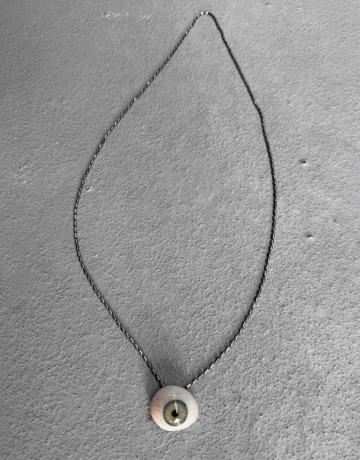 Necklace with a pendant on a gray textured background