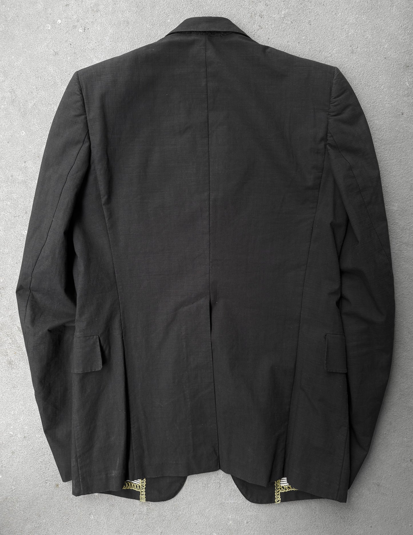 Black jacket with gold buttons on a gray background