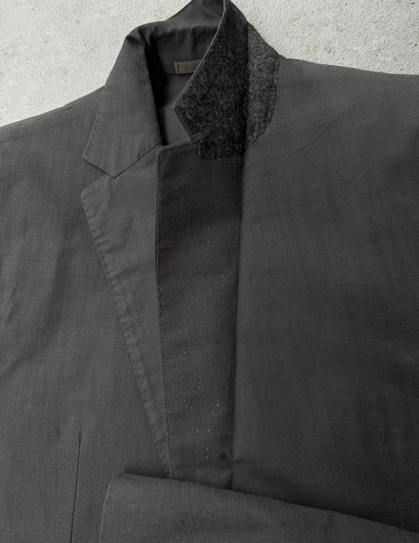 Dark gray coat with textured collar on a light gray background