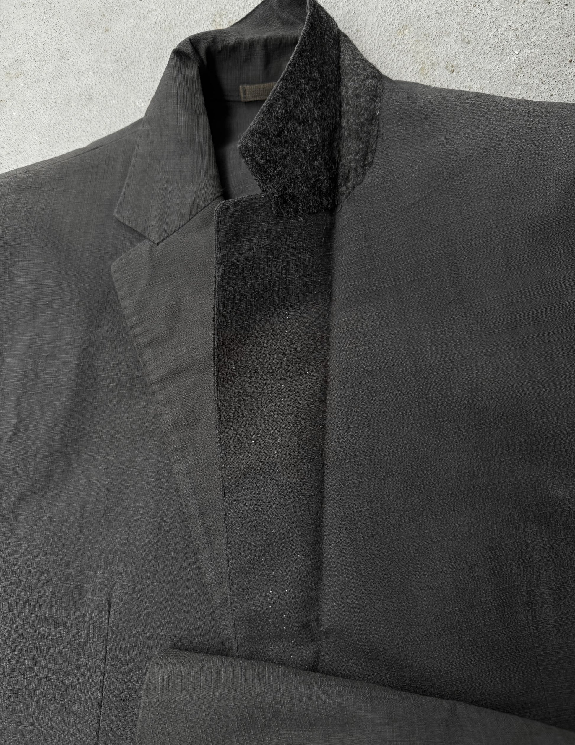 Dark gray coat with textured collar on a light gray background