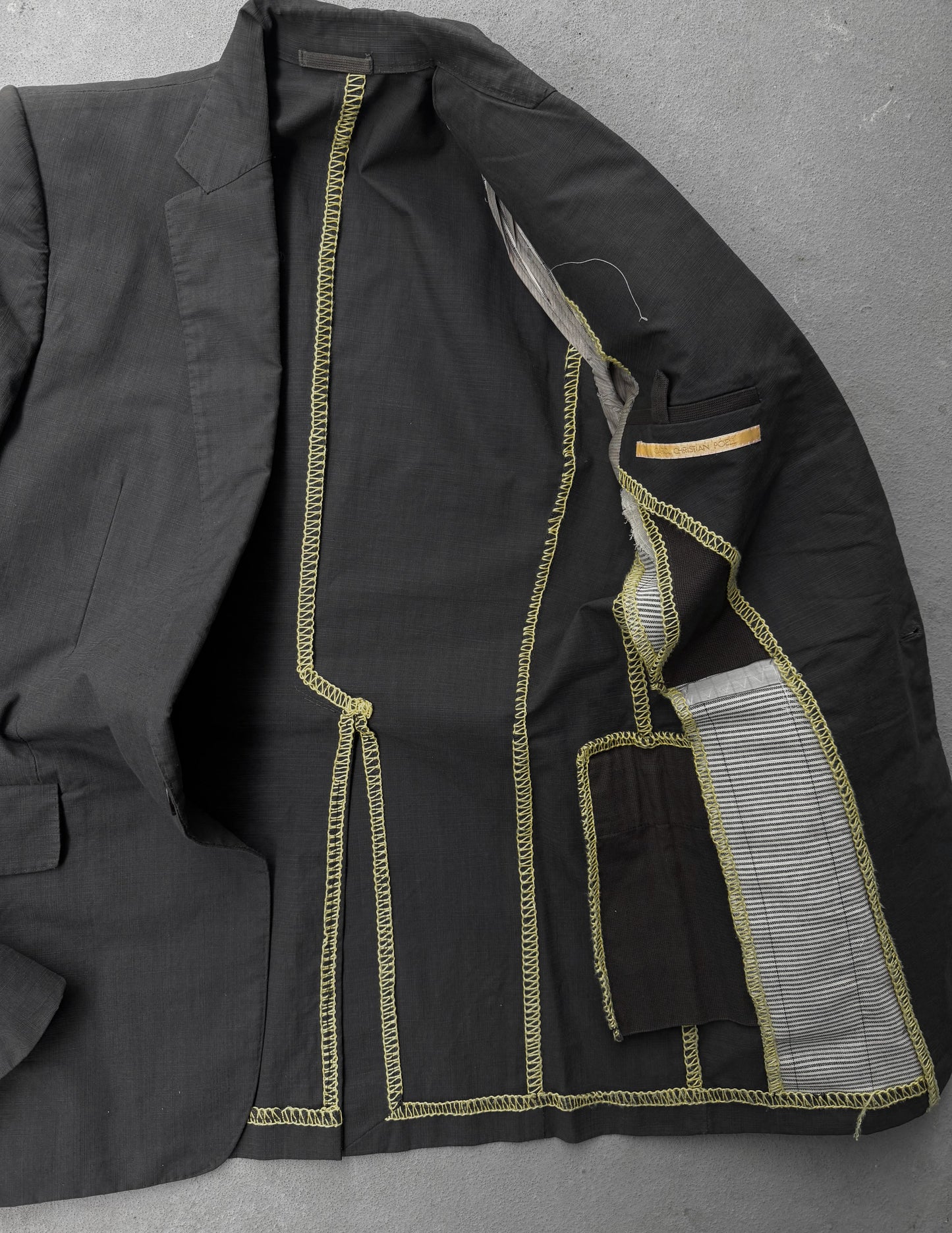 Black jacket with gold stitching on a gray background